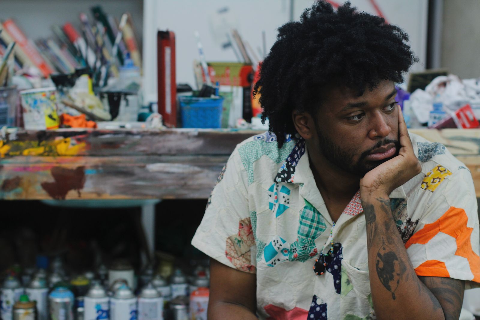 AJ Girard seated among paint supplies