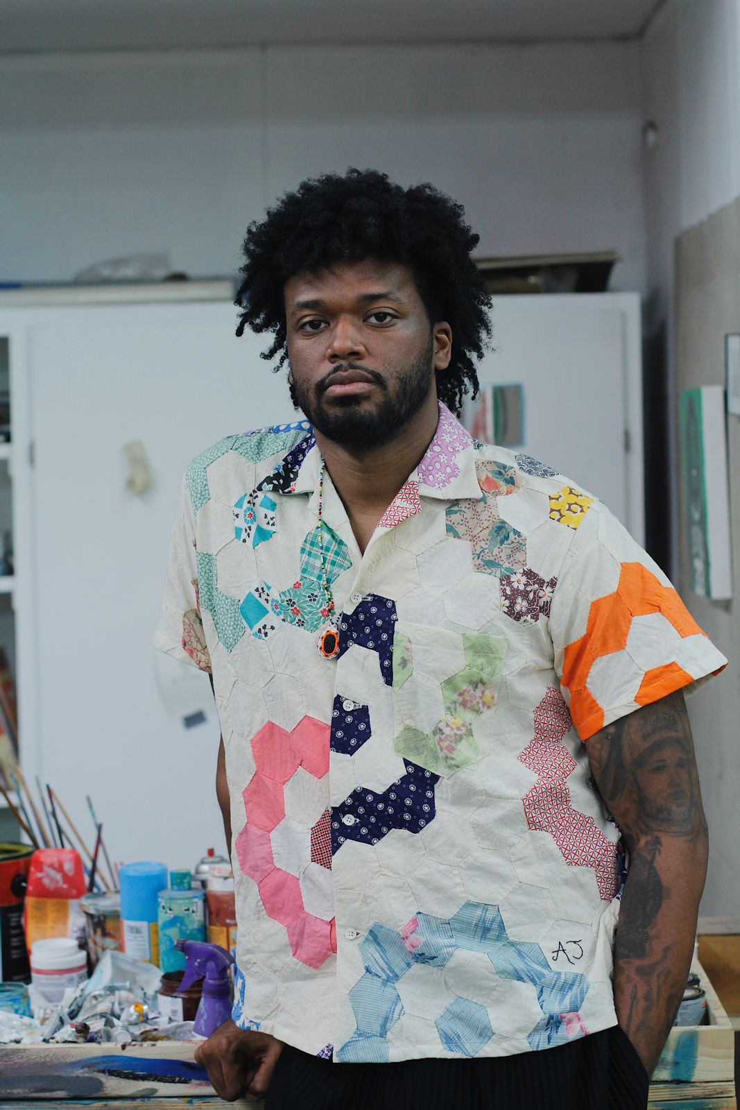 AJ Girard in a patchwork shirt in a studio