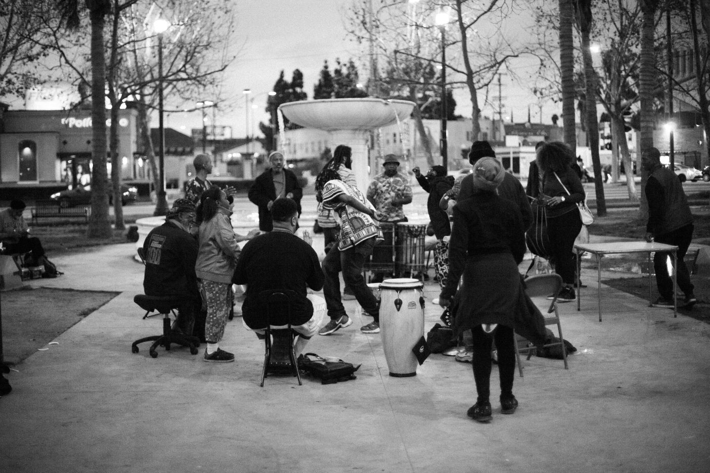 Drummers gathered around the Leimert Plaza fountain at dusk