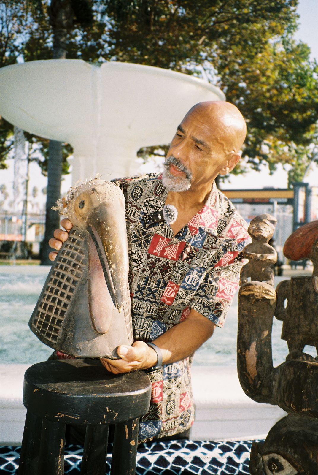 An artist holding a carved wooden piece at the plaza